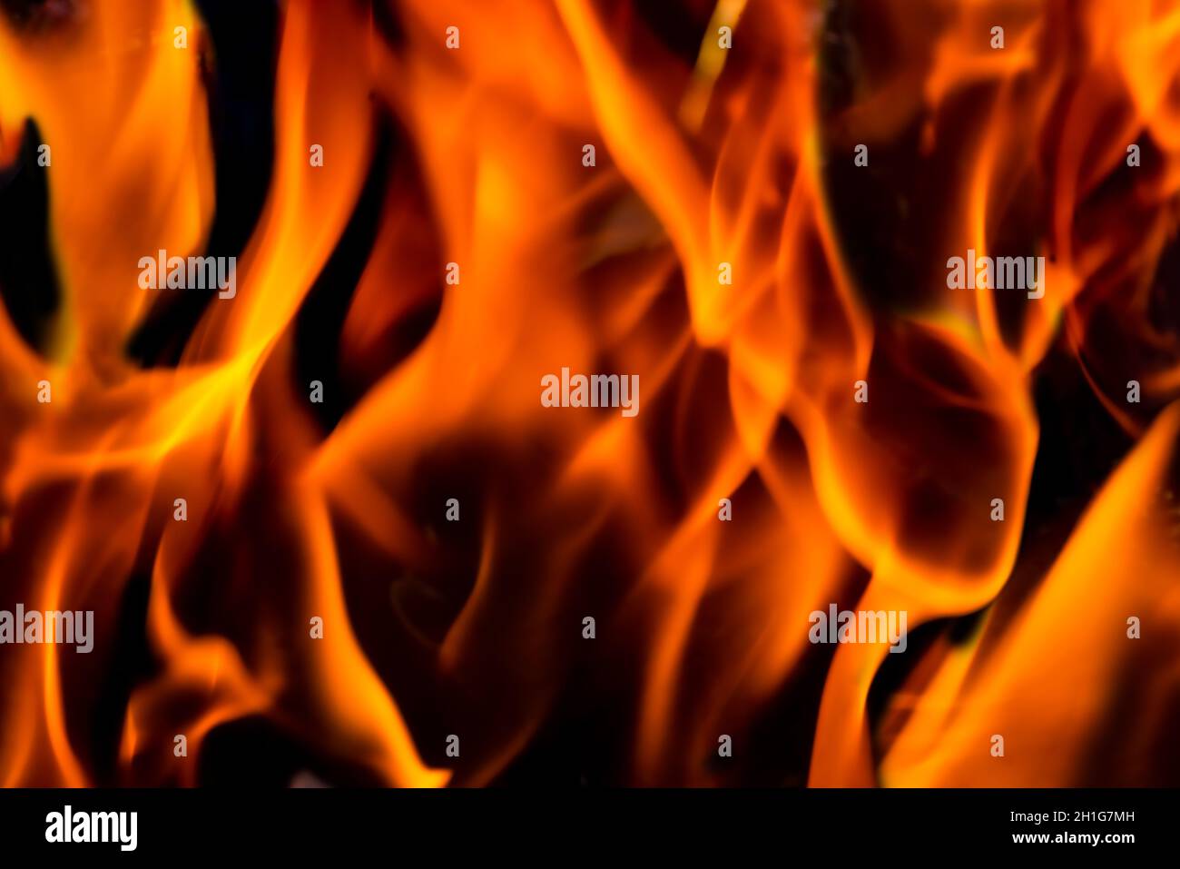 Feuer und Flammen mit einem brennenden dunkelrot-orangen Hintergrund Stockfoto