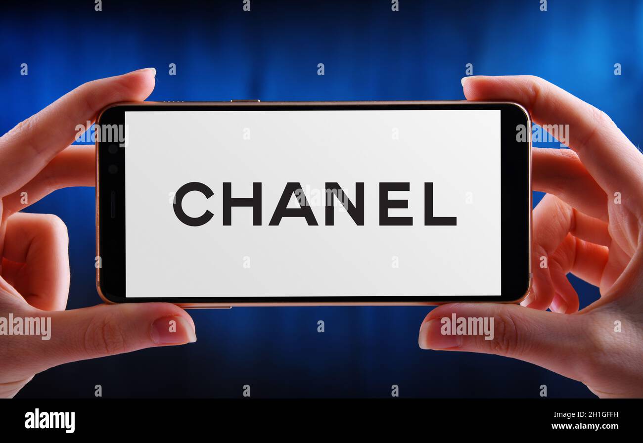 POZNAN, POL - JUN 12, 2020: Hand halten Smartphone mit Logo von Chanel, ein Luxus-Unternehmen, das sich auf High-Fashion und Ready-made Kleidung, l Stockfoto