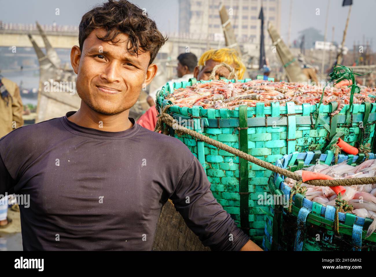 Chittagong, Bangladesch, 23. Dezember 2017: Porträt eines Fischers neben frischem Garnelenfang auf dem Fischmarkt in Chittagong Stockfoto