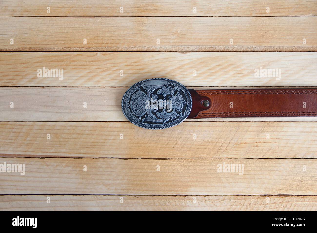 Cowboygürtel aus Leder auf einem Holzhintergrund Stockfoto