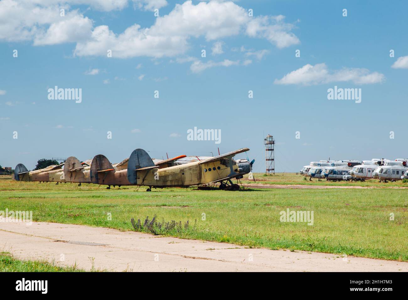 Alte zerstörte verlassene Flugzeuge und Hubschrauber auf dem Feld, Friedhof von alten Hubschraubern und Flugzeugen. Stockfoto