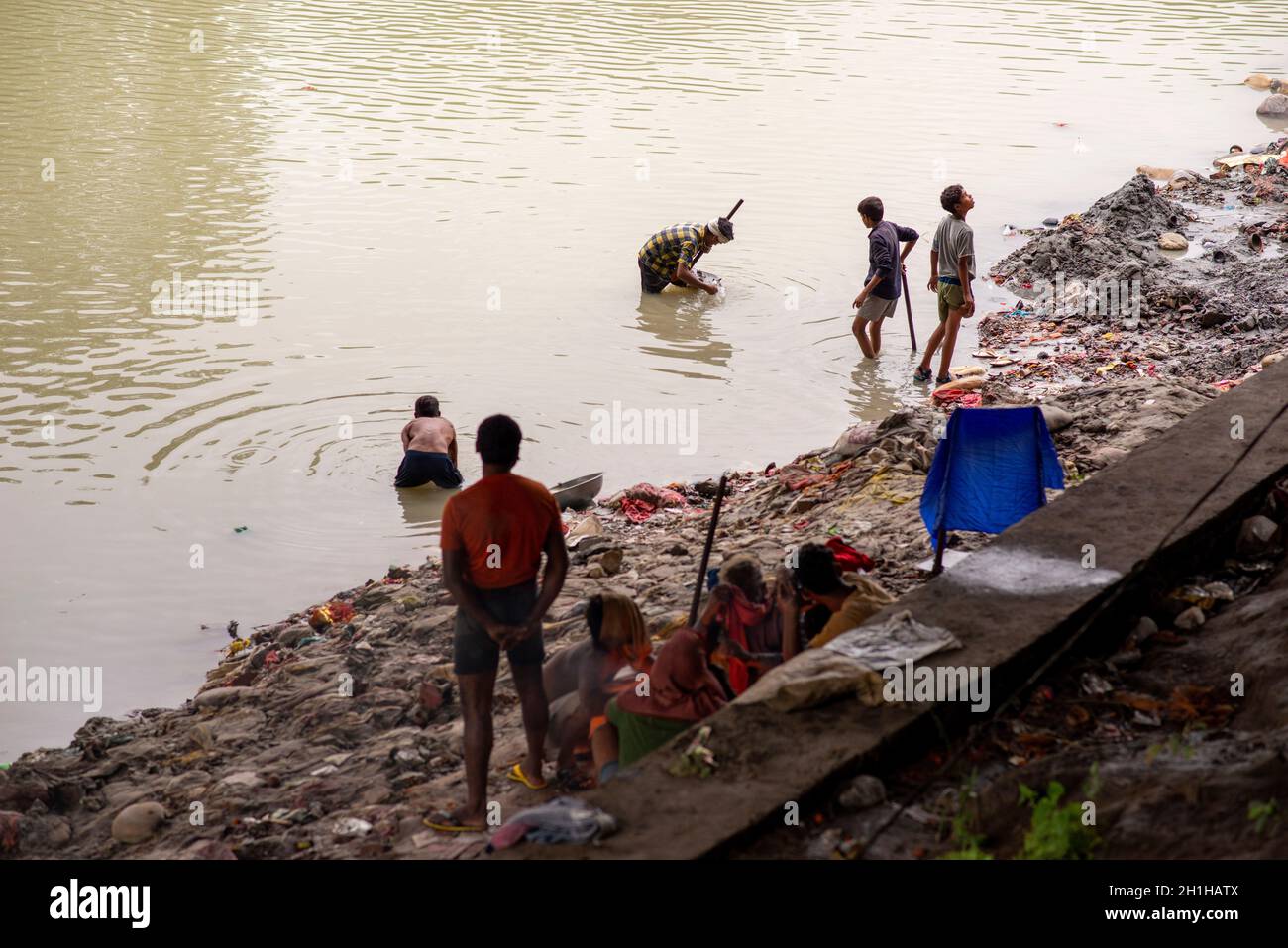 Muradnagar, Indien. Oktober 2021. In der Nähe des Ganges-Kanals bei Muradnagar suchen die Einheimischen nach wertvollen Gegenständen aus den Müllhaufen.im oberen Ganges-Kanal, der von schweren Bächen am Ufer des Kanals aufgetürmt wird, suchen die Einheimischen gerne nach wertvollen Gegenständen. Eifrige Anhänger bieten während eines Tauchgangs im Ganga-Kanal Wertsachen als religiöse Praxis an oder verlieren sie dort unwissentlich. (Foto von Pradeep Gaur/SOPA Images/Sipa USA) Quelle: SIPA USA/Alamy Live News Stockfoto