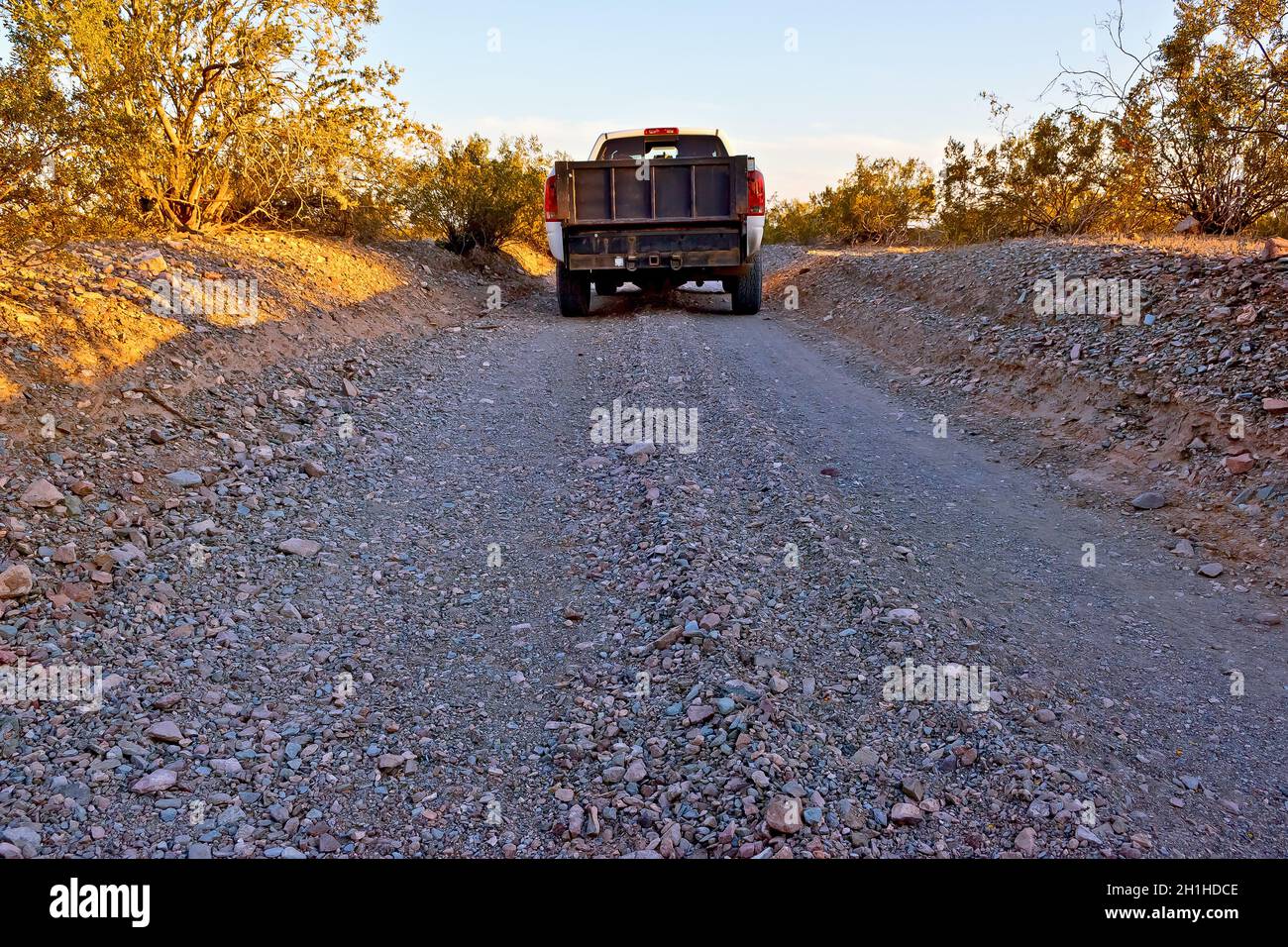 Eine sehr schmale Schotterstraße in einem abgelegenen Gebiet in der Nähe von Tonopah Arizona. Die Straße ist so schmal, dass jeweils nur ein Fahrzeug durchfahren kann. Stockfoto