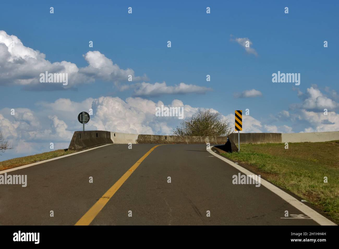 Sicht des Fahrers auf ein Auto bei einem Anstieg, der Zugang zu einer Autobahn-Rückkehrbrücke ermöglicht. Stockfoto