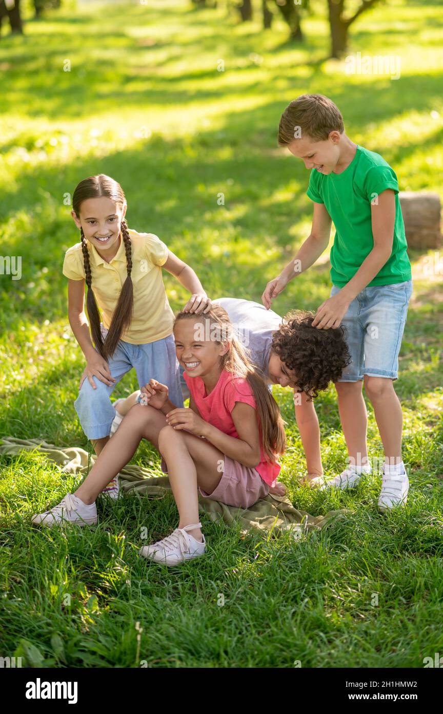 Glückliche Kinder spielen auf dem Rasen im Park Stockfoto
