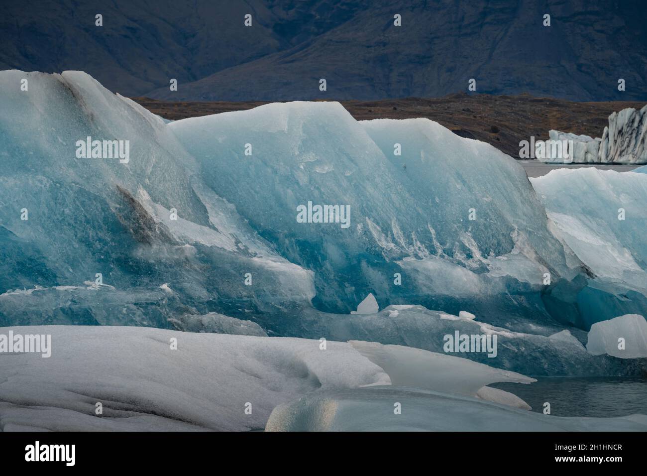 Eisberge schweben. ICES und Eisberge. Gletscherlagune. Grönländischer Eisberg. Schmelzendes Eis. Südküste Islands. Jokullsarlon Gletscherlagune. Vulkanasche Stockfoto