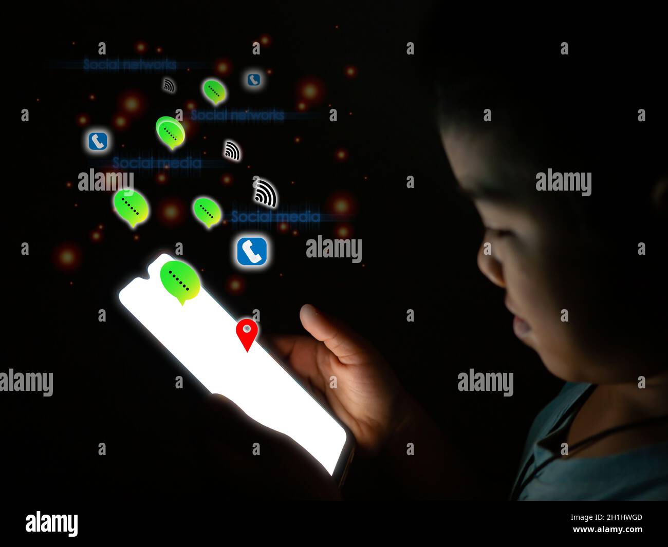 Boy hält den Telefonbildschirm ist leer und hat ein Social-Media-Symbol auf einem dunklen Hintergrund gesetzt. internet und Kommunikationskonzept. Stockfoto
