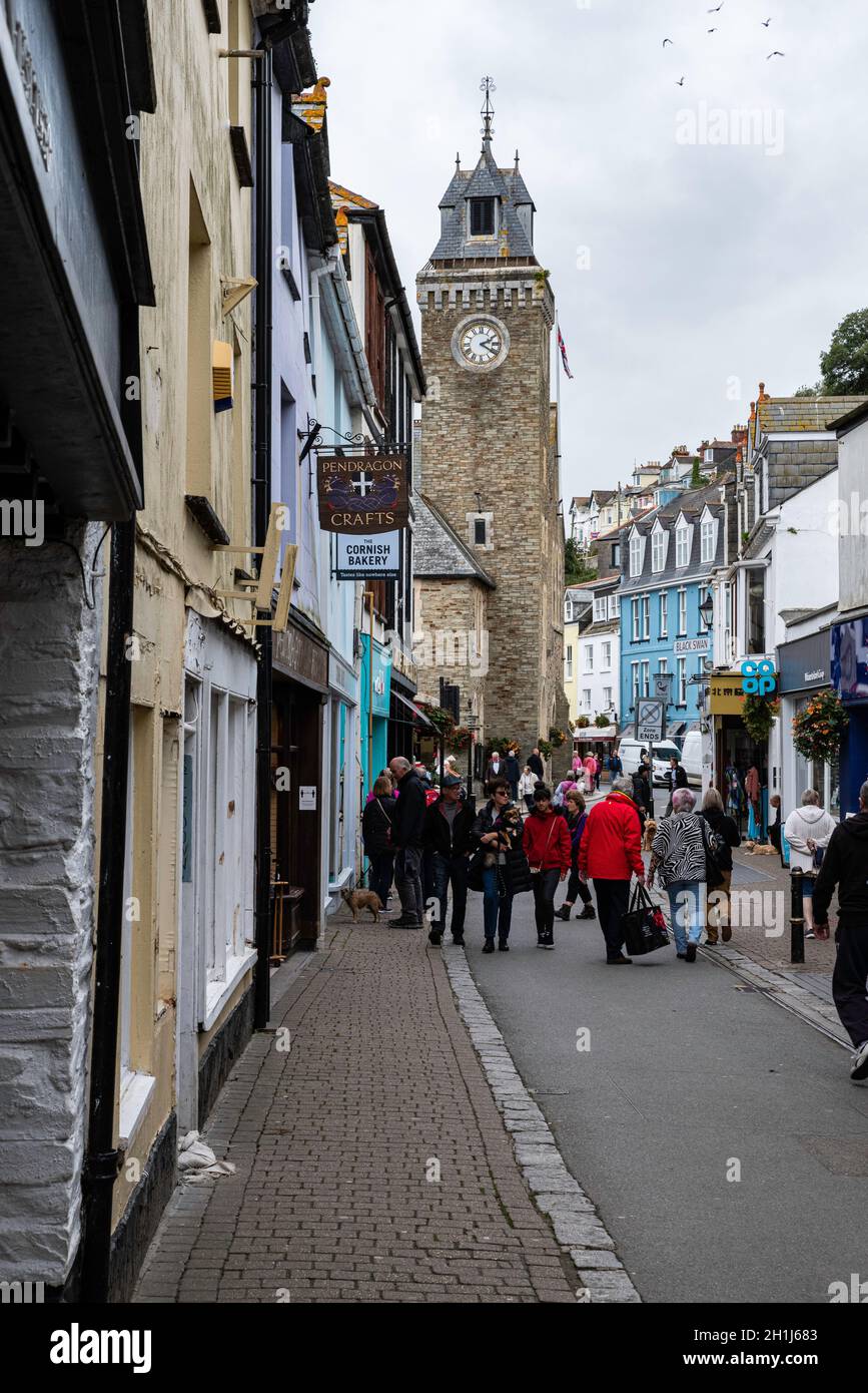 Außerhalb der Saison Besucher in der Fore Street mit dem prominenten Uhrenturm, Looe, Cornwall. Ein funktionierendes Fischerdorf, das bei Urlaubern beliebt ist. Stockfoto