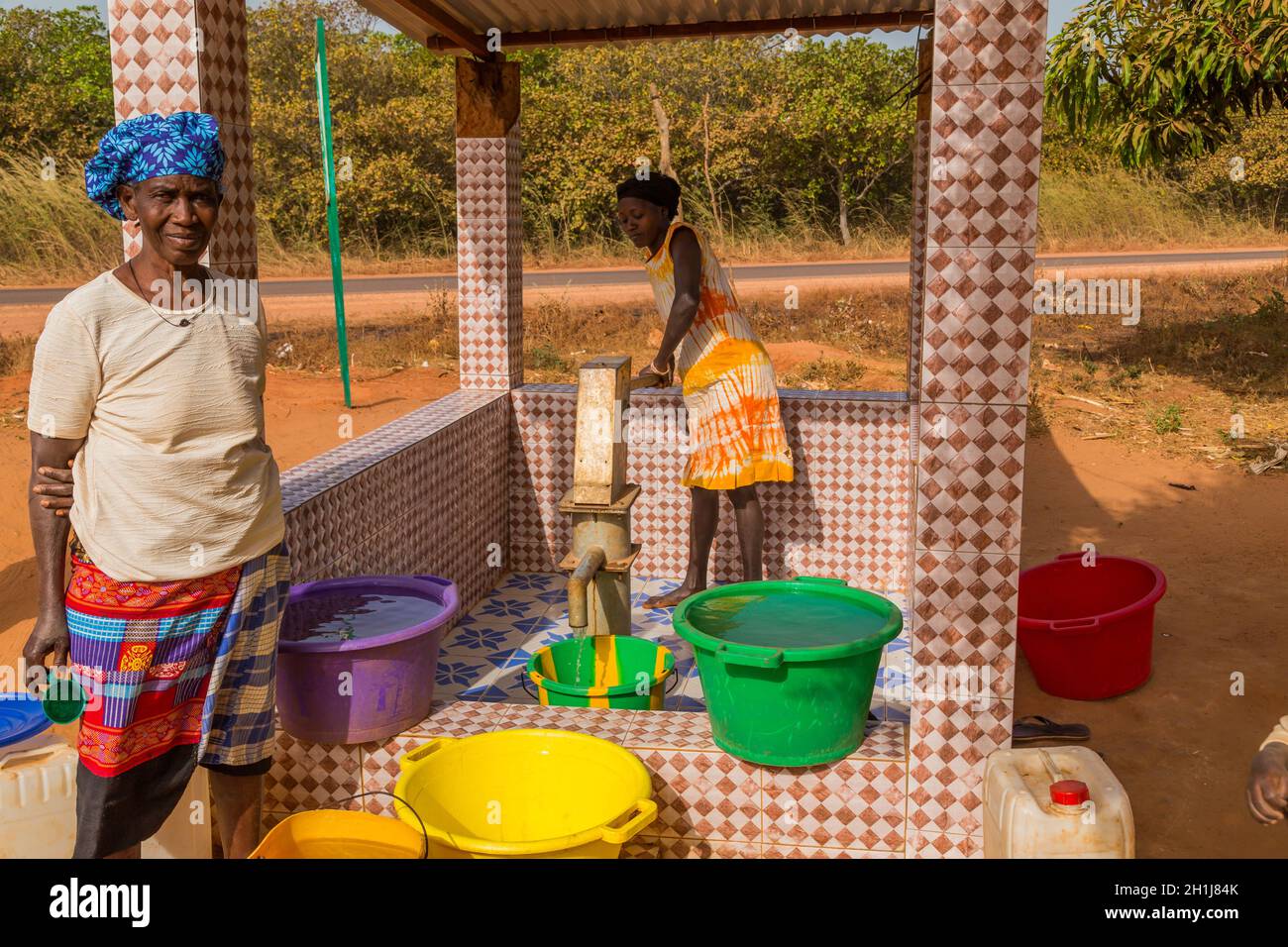 Bissau, Republik Guinea-Bissau - 6. Februar 2018: Frauen und Kinder am Brunnen für Wasser, in der Stadt Bissau, Guinea-Bissau Stockfoto