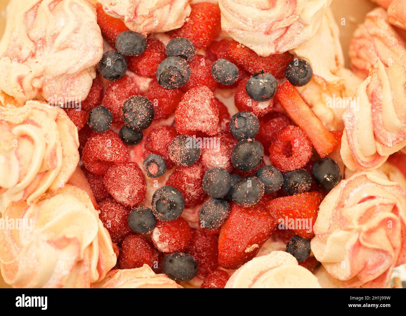 Köstlich süßes, rosa Baiser, gefüllt mit Beeren für eine Hochzeit. Stockfoto