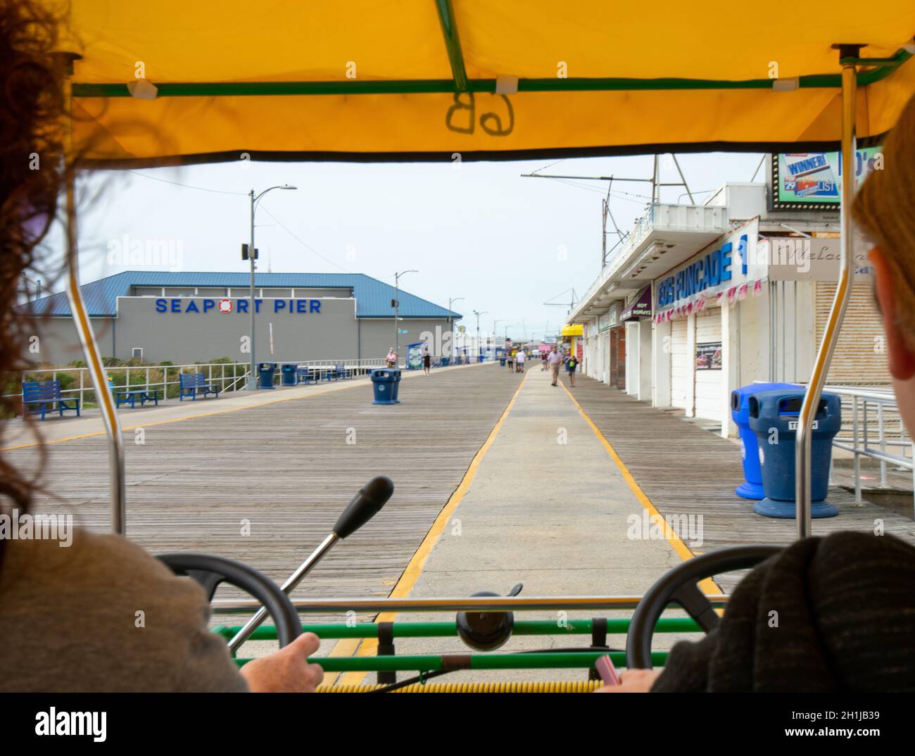 Blick von der Rückseite eines viersitzigen Fahrrads auf Der Wildwood Boardwalk ist zwischen zwei Personen Stockfoto
