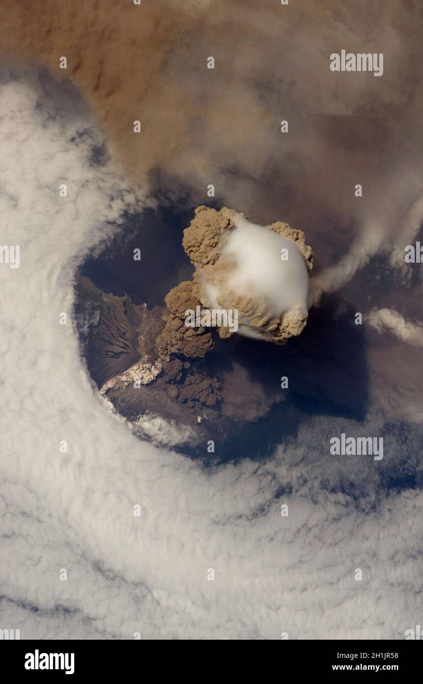 Die Erde von der Internationalen Raumstation aus gesehen: Sarychev Peak Eruption, Kuril Islands. In einem frühen Stadium des Ausbruchs am 12. Juni 2009. Der Sarychev Peak ist einer der aktivsten Vulkane der Kuril-Inselkette und liegt am nordwestlichen Ende der Insel Matua. Das Bild zeigt mehrere Phänomene, die während der frühesten Stadien eines explosiven Vulkanausbruchs auftreten. Die Hauptsäule ist eine einer Reihe von Federn, die am 12. Juni über Matua Island stiegen. Eine optimierte und verbesserte Version eines NASA-Bildes / Credit NASA. Stockfoto