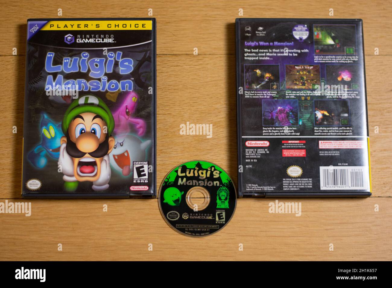 Eine Disc und ein Etui für Luigi's Mansion für die Nintendo Gamecube auf einem Holzboden. Stockfoto