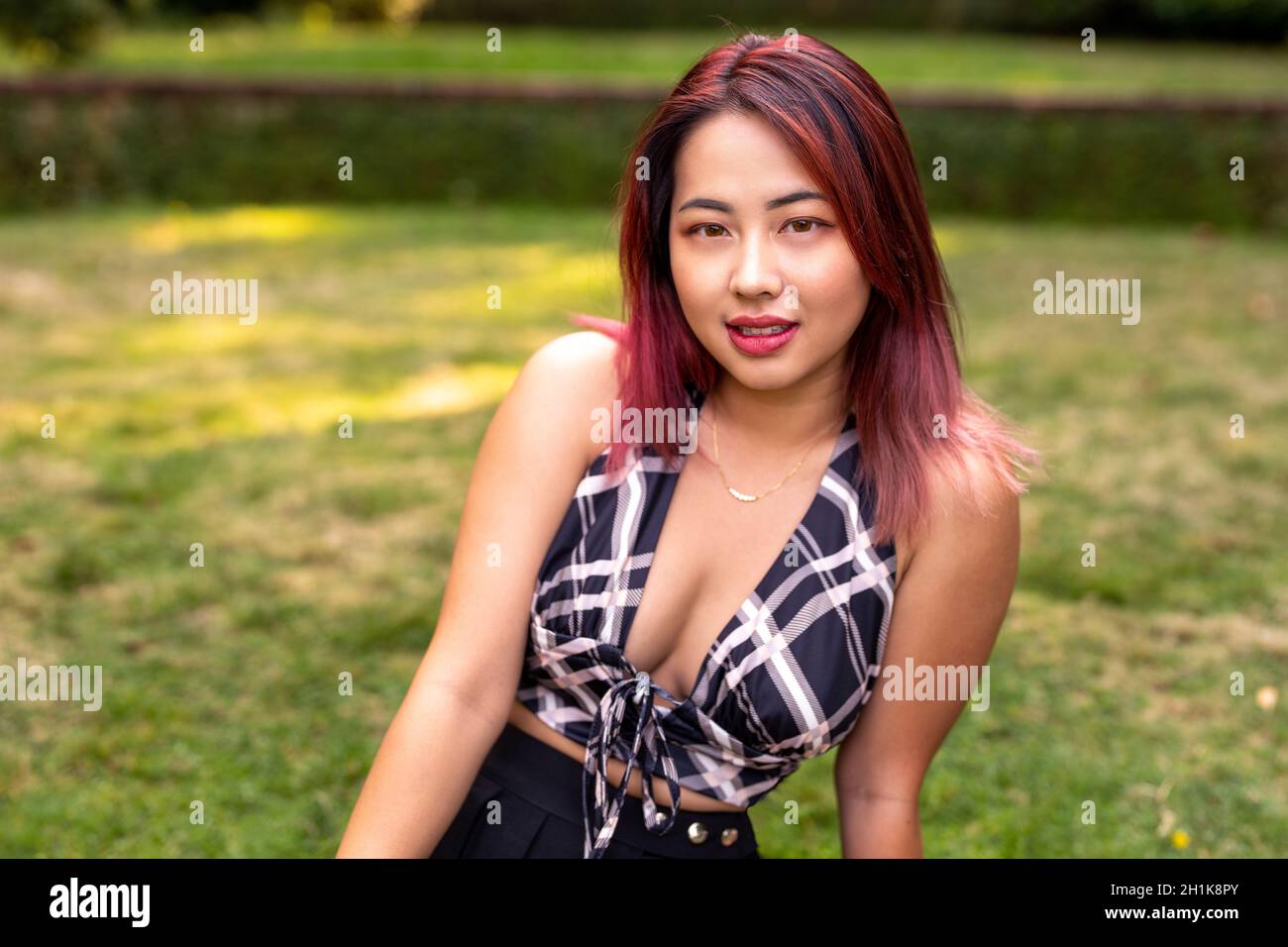 Junge kantige asiatische Frau in einem Garten Stockfoto