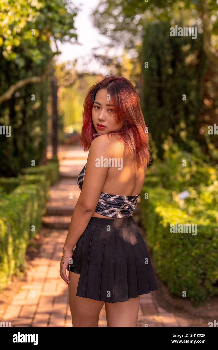 Junge kantige asiatische Frau in einem Garten Stockfoto