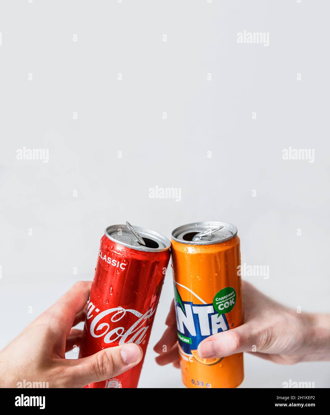 Minsk, Weißrussland - 18. September 2020: Zwei Hand machen mit Coca-Cola und Fanta Dosen. Zwei Getränke, die von der Coca-Cola Company hergestellt werden Stockfoto