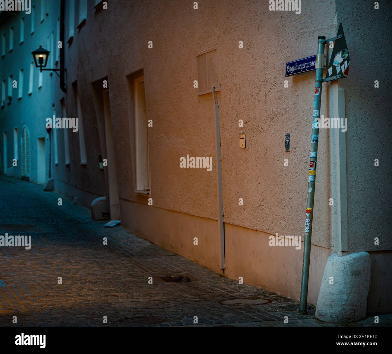 Alte Stadtstraße mit Dämmerung in enger Gasse und gemütliche Laterne mit Licht. Deutschland, Bayern, Europa reisen. Stockfoto