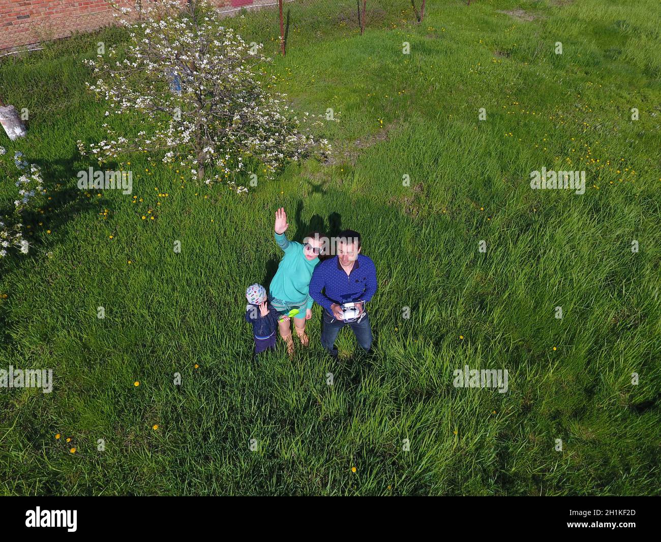 Ein Mann und eine Frau werden von einer Drohne auf einer grünen Lichtung fotografiert Stockfoto
