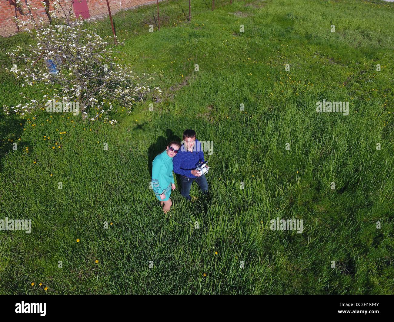 Ein Mann und eine Frau werden von einer Drohne auf einer grünen Lichtung fotografiert Stockfoto