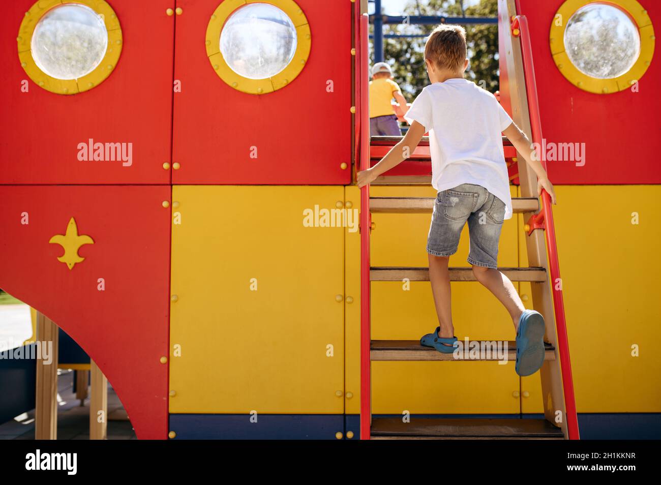 Kleiner Junge leisiert auf dem Spielplatz, glückliche Kindheit. Kind spielt auf dem Trampolin, Extremsportabenteuer im Urlaub, Gefahr Unterhaltung im Freien Stockfoto