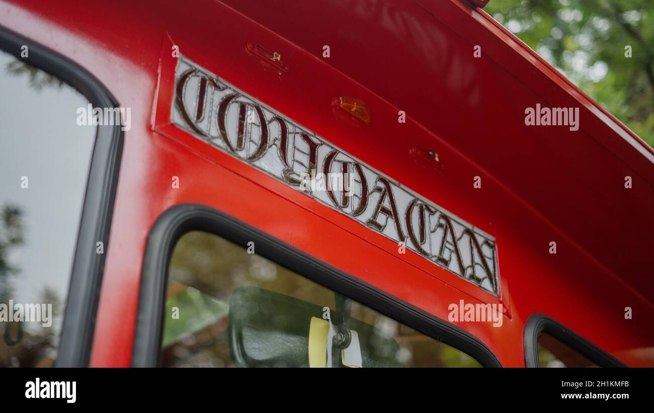 Bild eines Coyoacan-Schildes auf einer rot-gelben Straßenbahn, die auf einer Straße fährt, mit Bäumen im Hintergrund. Der Text 'Coyoaca' ist der Name der ne Stockfoto