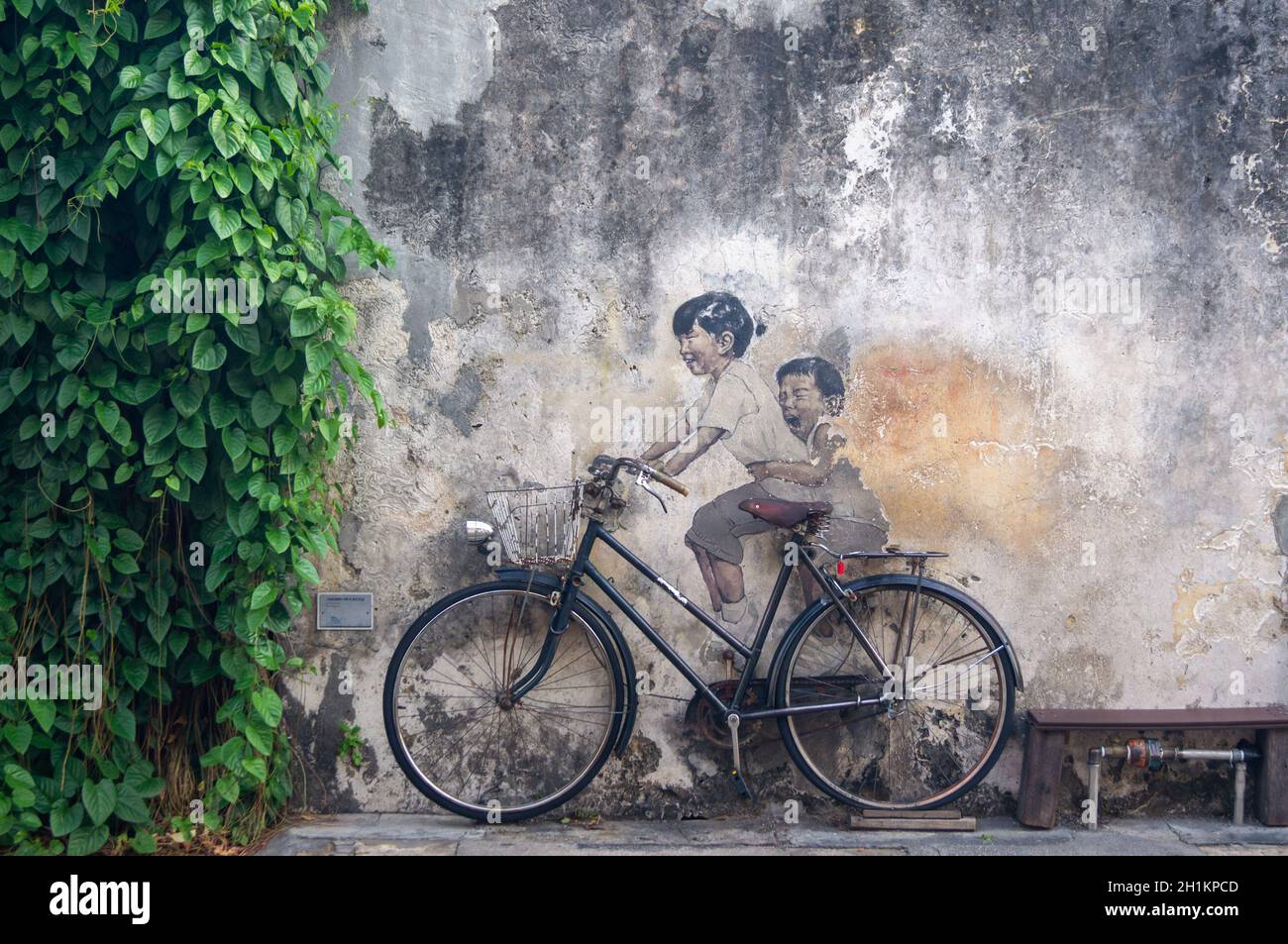 Georgetown, Penang/Malaysia - 14 2020. Februar: Kleine Kinder auf einem Fahrrad, gemalt von Ernest Zacharevic Stockfoto