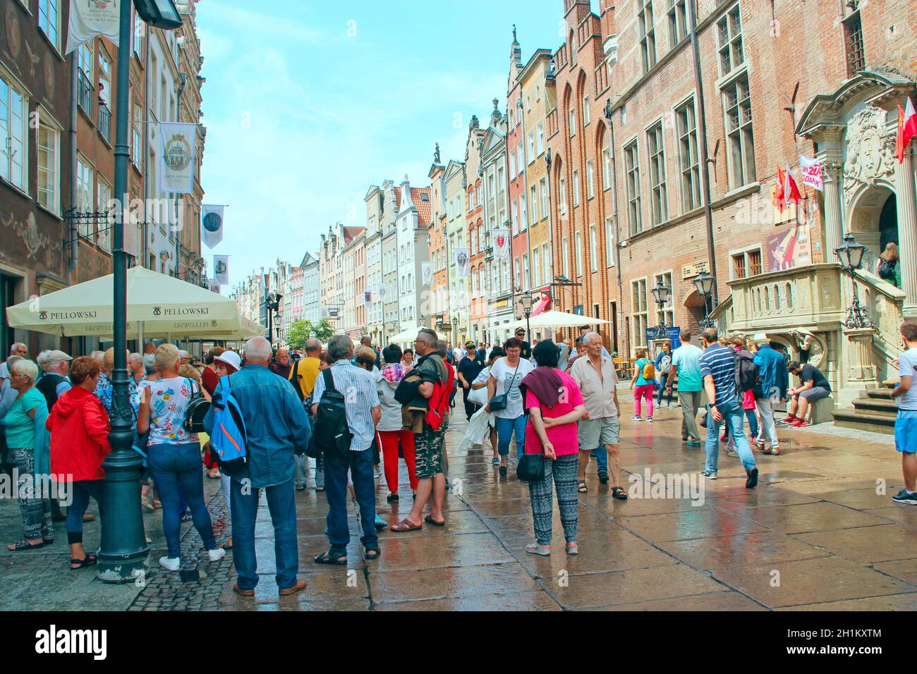 Touristen schlendern bei Regen über Danzig. Viele Touristen gehen durch Danzig. Schöne touristische polnische Stadt Danzig. Gruppe von europäischen Touristen während jo Stockfoto