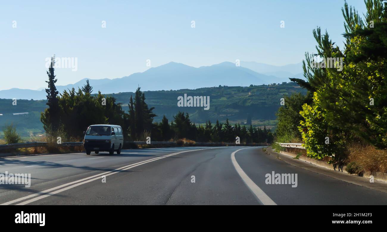 Auto auf der Straße und Berge dahinter in Kreta, Griechenland Stockfoto