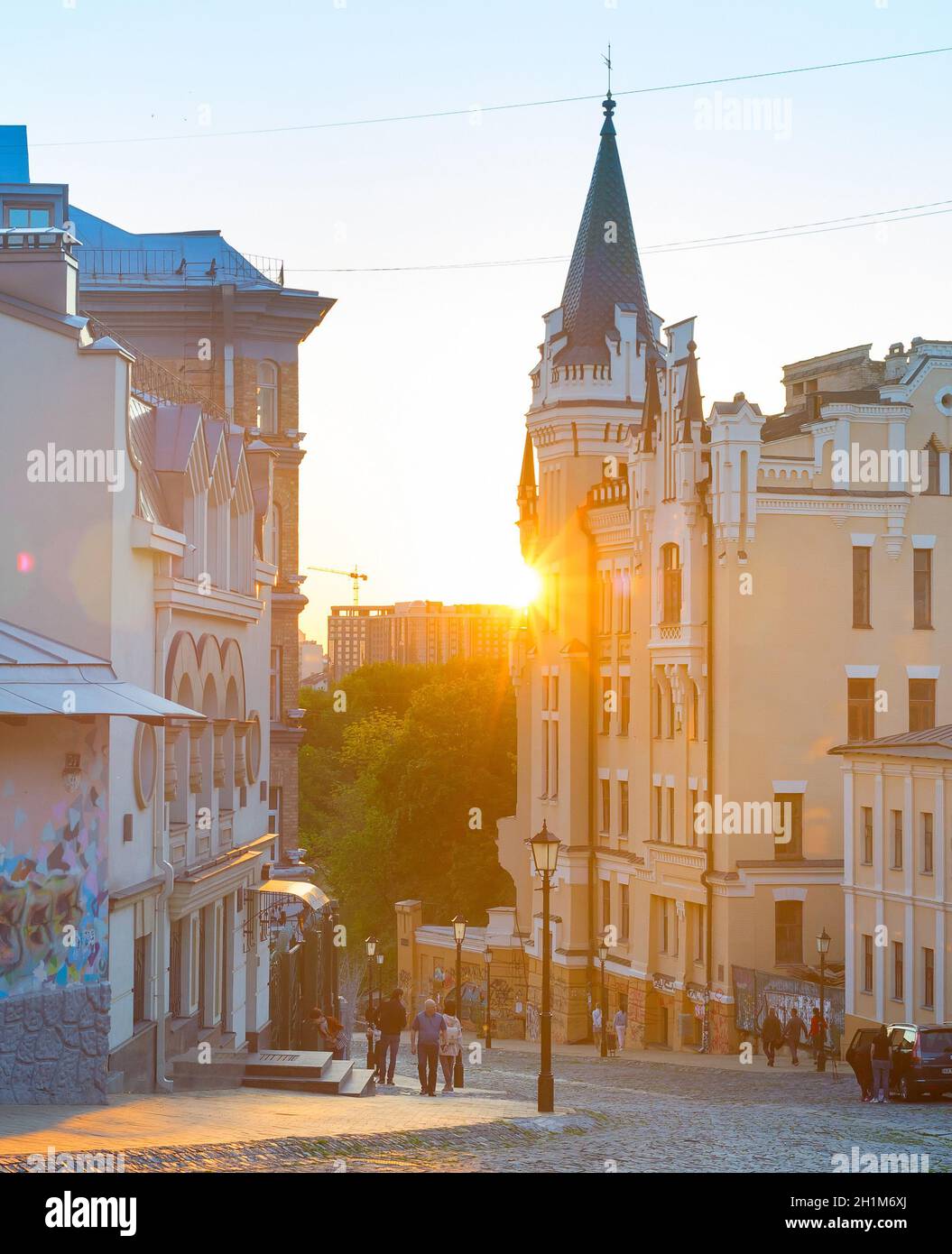 KIEW, UKRAINE -10. MAI 2020: Menschen, die an Andrews vorbei gehen, steigen bei Sonnenuntergang ab. Andrews Abstammung ist ein berühmtes Touristenziel. Stockfoto