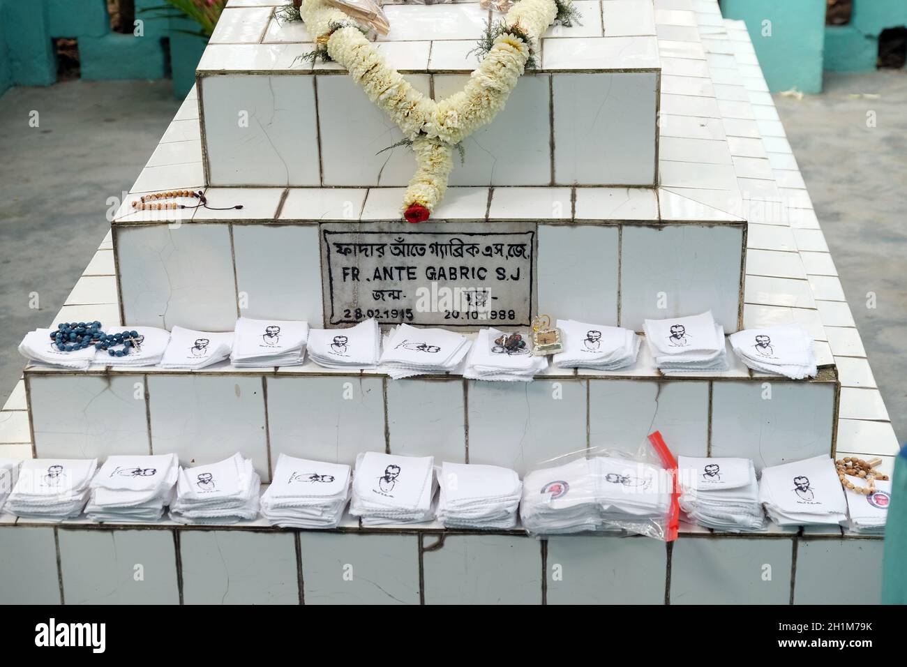 Religiöse Objekte warten auf einen Segen auf dem Grab kroatischer Missionare, dem jesuitischen Vater Ante Gabric in Kumrokhali, Westbengalen, Indien Stockfoto