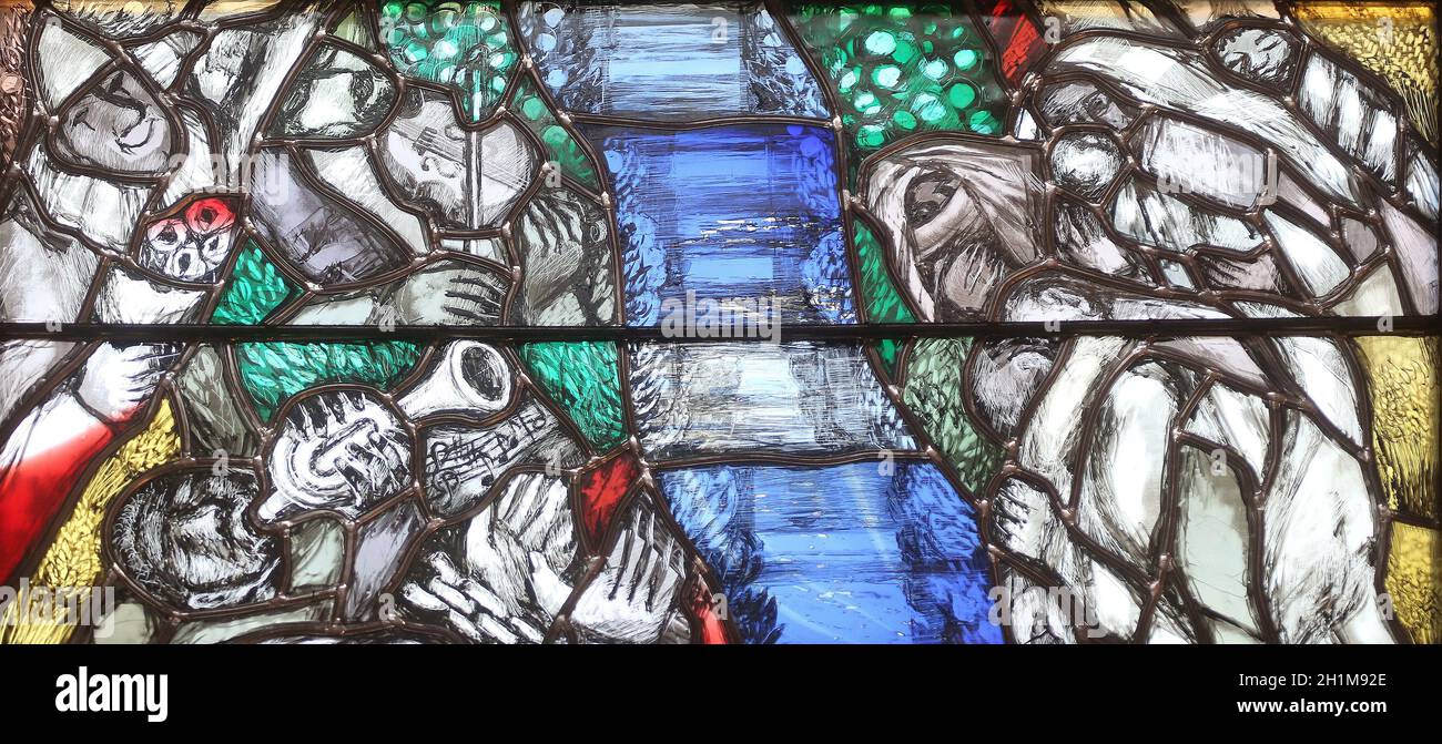 Gott trägt die Schuld der ganzen Menschheit, ergreift Sünder und rettet sie vor dem Tod, Detail des Glasfensters von Sieger Koder in der St.-John-Kirche Stockfoto