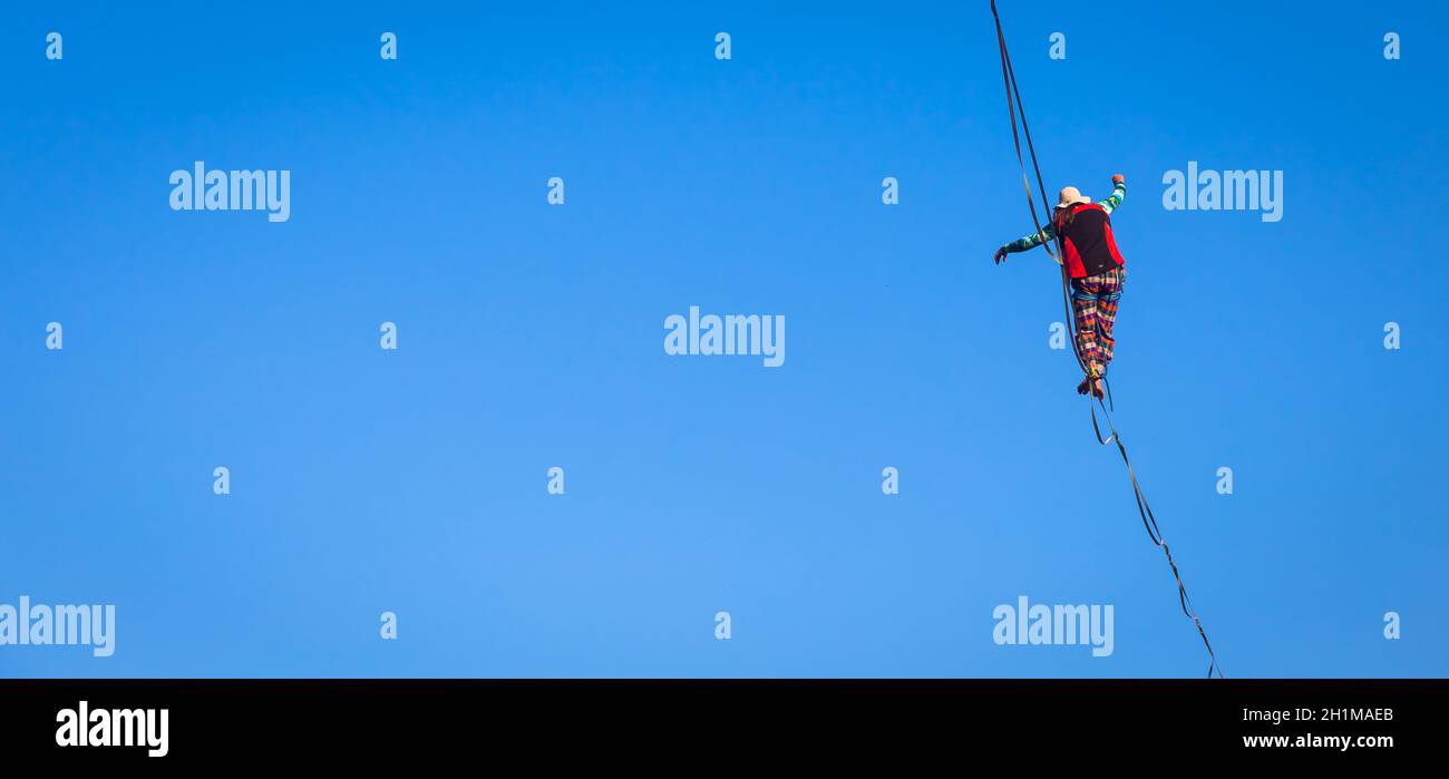 LANZO, ITALIEN - CA. OKTOBER 2020: Slackline-Athlet während seiner Performance. Konzentration, Balance und Abenteuer in diesem dynamischen Sport. Stockfoto