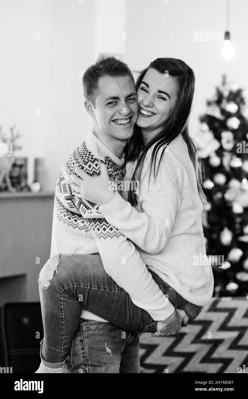 Ein Mann und ein Mädchen feiern gemeinsam das neue Jahr In einer warmen Atmosphäre und geben einander Geschenke Stockfoto