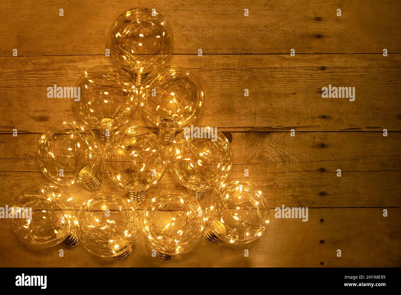 Weihnachtsbaum mit LED-Garkand auf einem Holzhintergrund Flatlay ausgekleidet Stockfoto