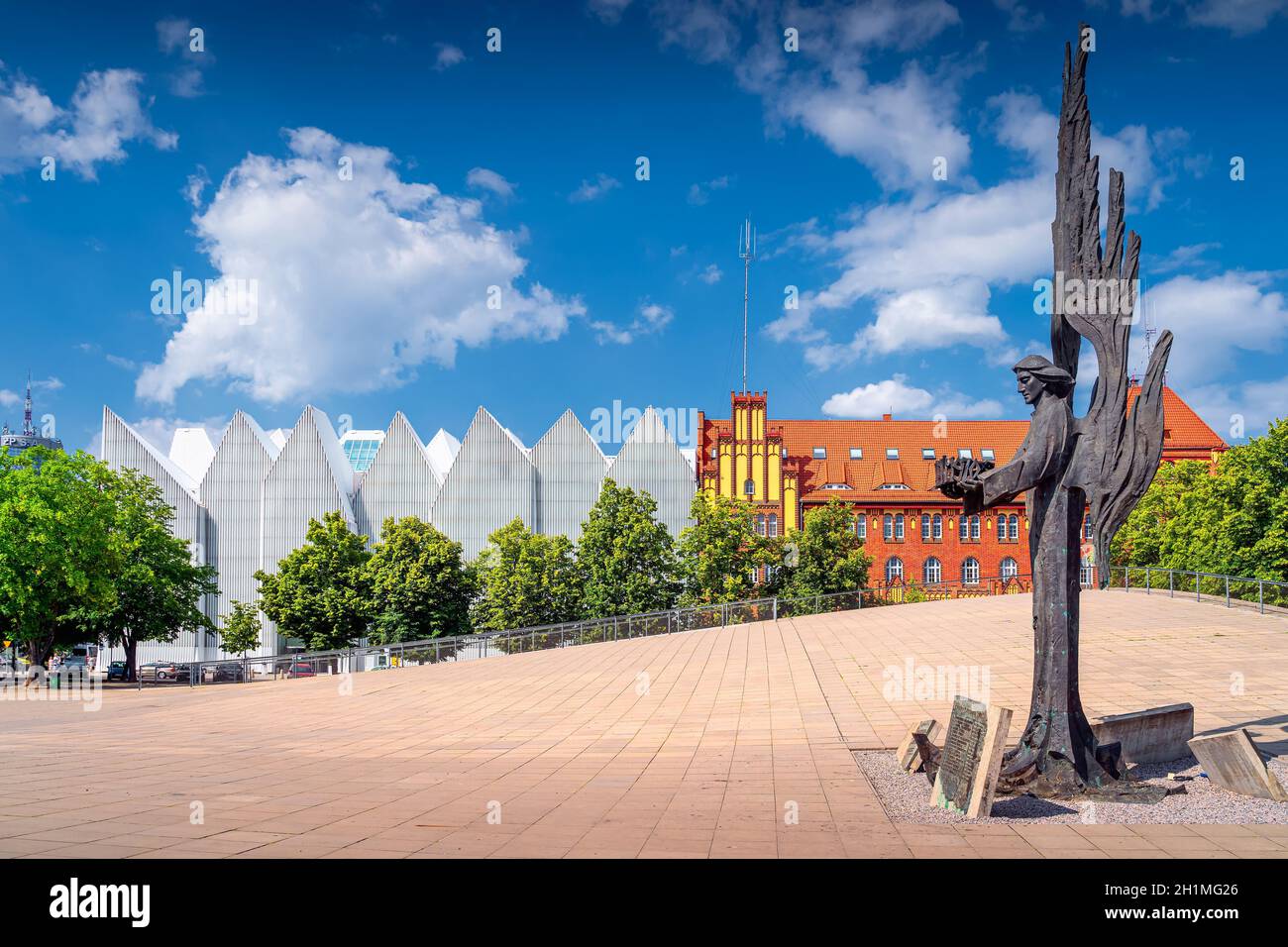 Szczecin, Polen, Juni 2019 Angle of Freedom, ein Denkmal für die Opfer des 1970. Dezember auf dem Solidaritätsplatz mit dem philharmonischen Gebäude im Hintergrund Stockfoto Szczecin, Polen, Juni 2019 Angle of Freedom, ein Denkmal für die Opfer des 1970. Dezember auf dem Solidaritätsplatz mit dem philharmonischen Gebäude im Hintergrund Stockfoto