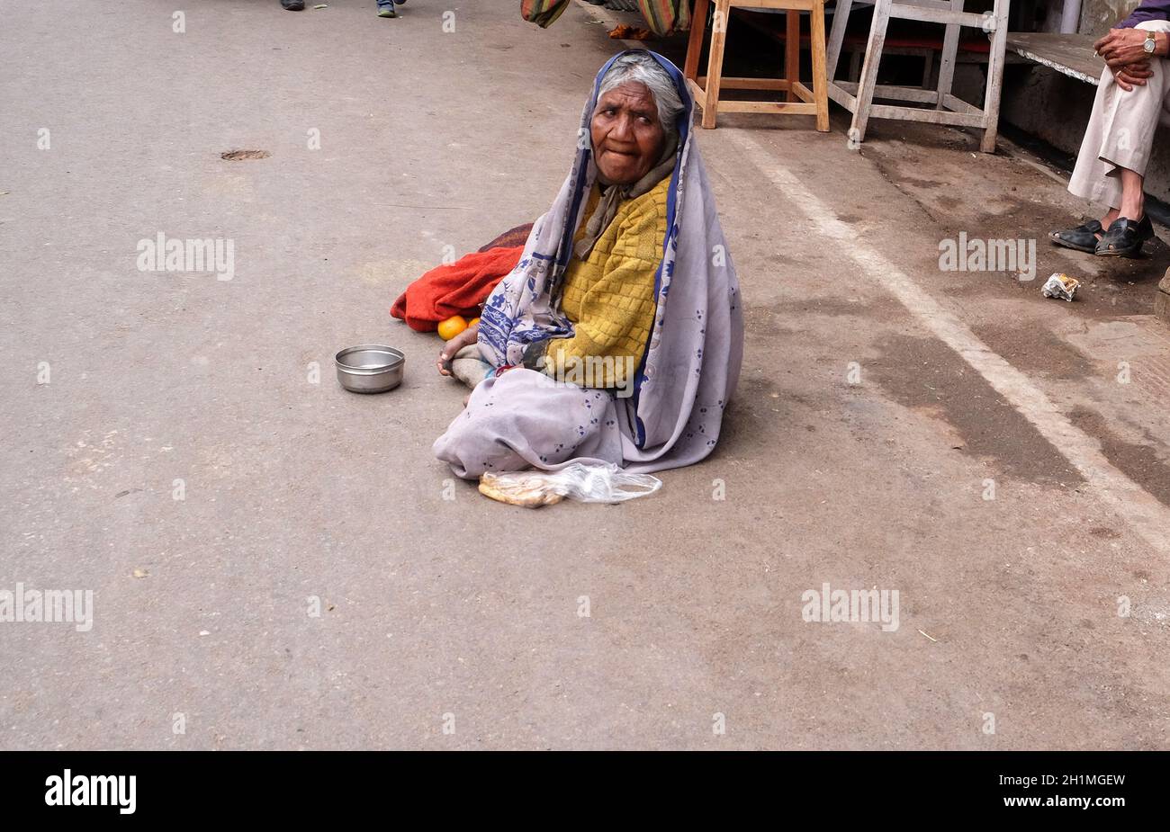 Der Bettler wartet auf Almosen auf einer Straße auf dem Ghat entlang des heiligen Sarovar-Sees in Pushkar, Indien Stockfoto