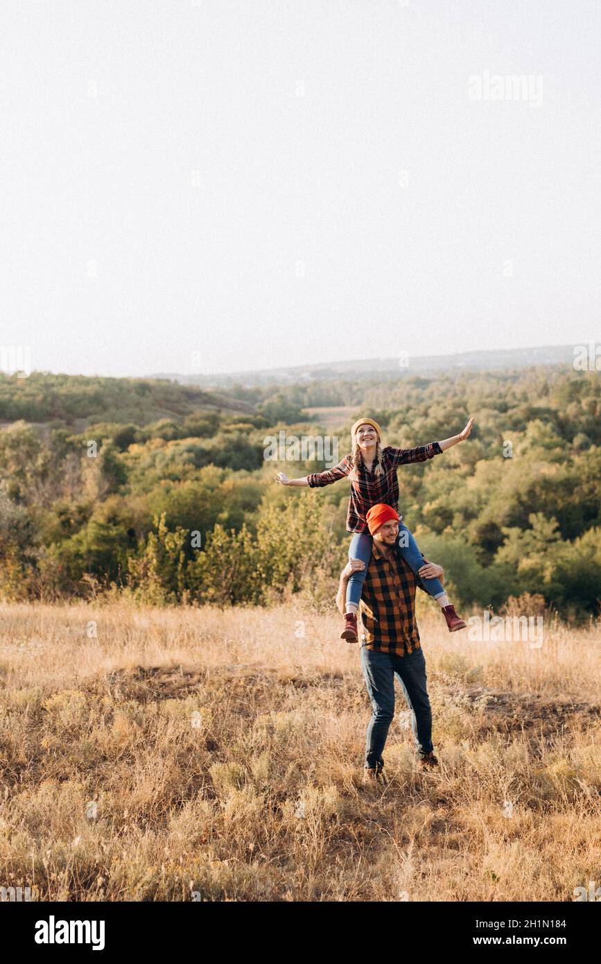 Fröhlicher Kerl und Mädchen auf einem Spaziergang in hell gestrickt Mützen und karierten Hemden Stockfoto