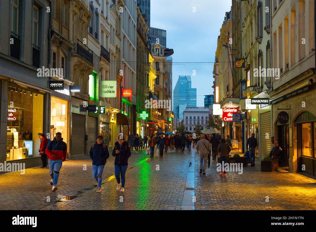 BRÜSSEL, BELGIEN - 06. OKTOBER 2019: Menschenmenge, die in der Dämmerung an der Einkaufsstraße der Altstadt von Brüssel spazieren Stockfoto