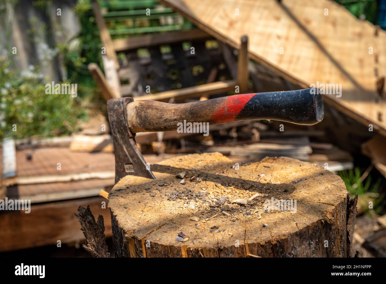 Metallaxt in einem Holzbalken auf dem Land. Stockfoto