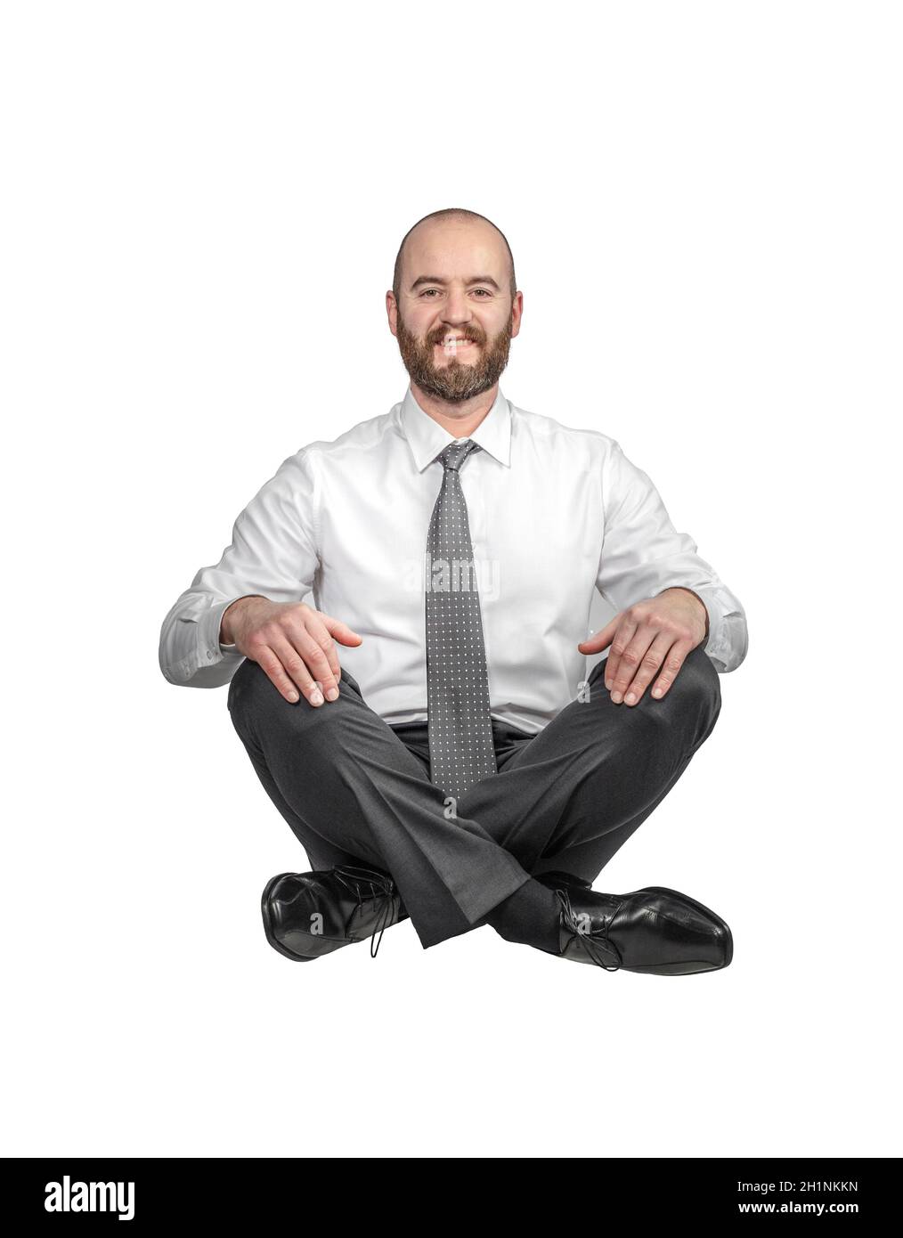 Isoliert lächelnd gekreuzte Beine sitzenden Geschäftsmann. Stockfoto