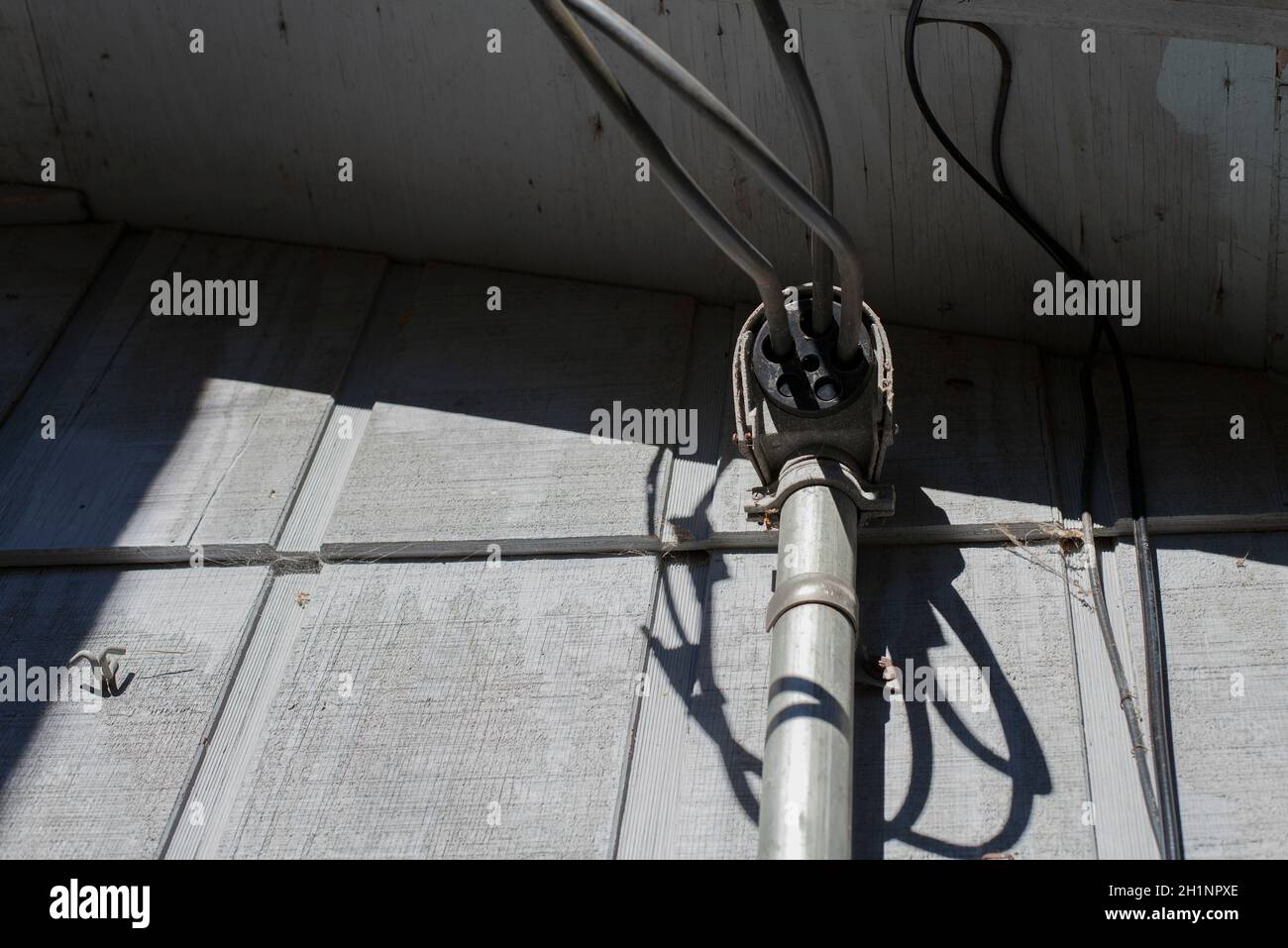 Kabel, die von der Seite eines Hauses hängen Stockfoto