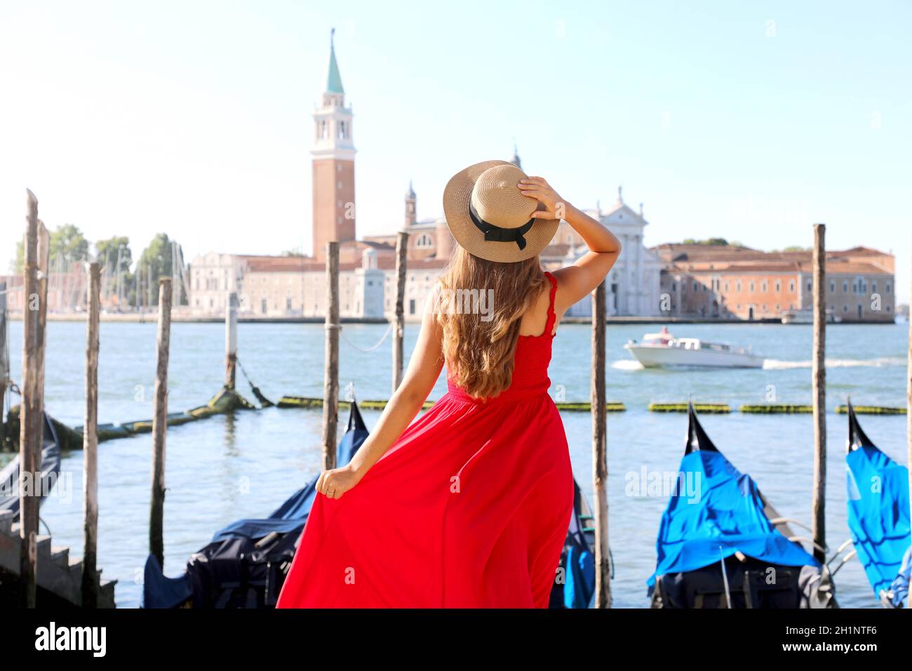 Mädchen, die Venedig in Italien besucht. Rückansicht der schönen jungen Frau in roten Kleid genießen Blick auf die Lagune von Venedig. Stockfoto