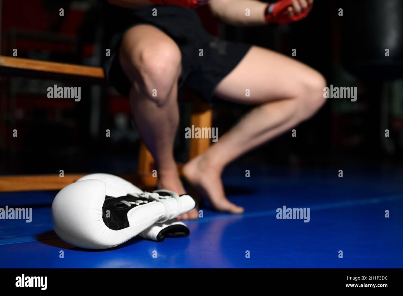 Nahaufnahme der Boxerbeine, die nach dem Training auf der Bank im Fitnessstudio ruhen. Hochwertige Fotos Stockfoto
