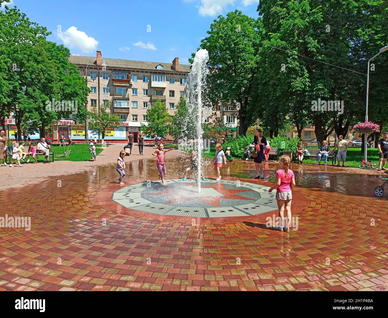 Kinder haben Spaß mit Stadtbrunnen während der Sommerhitze. Kinder spielen an heißen Sommertagen mit Wasserstrahlen. Hitze in der Stadt. Heißer Sommertag Stockfoto