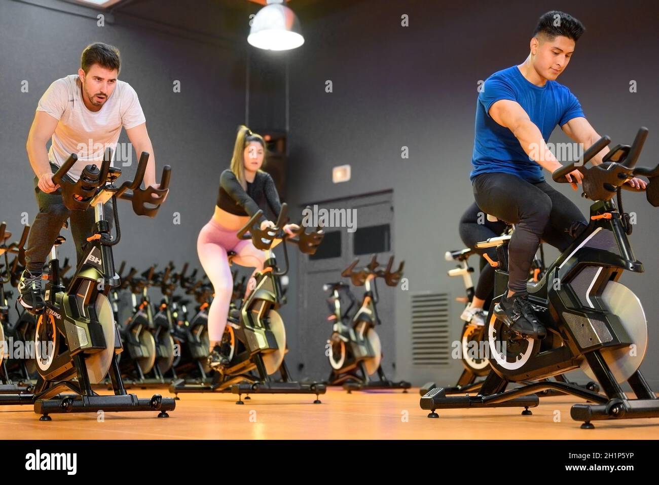 Gruppenzyling auf einem modernen Fitnessfahrrad während des Gruppenzyling-Kurses im Fitnessstudio. Hochwertige Fotos Stockfoto