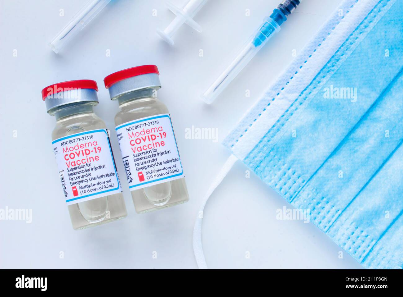 Calgary, Alberta. Kanada. Januar 25 2021. Ein paar Impfstoffflaschen Moderna Covid-19 mit sterilen Spritzen und Gesichtsmaske Stockfoto