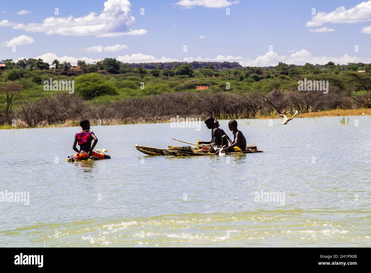 Nakuru, Rift Valley, Kenia. Oktober 2021. Jungen, die angeln, werden in einem traditionellen Balsa-Holzfloß im Baringo-See segeln sehen.die durch den Klimawandel verschärfte Überschwemmungssituation in Rift Valley Seen hat zu der Vertreibung von Tausenden von Menschen aus ihren Häusern und ihrer Arbeit geführt. Es gibt immer mehr Aufrufe an die Staats- und Regierungschefs der Welt, mehr Anstrengungen zu Unternehmen, um die Auswirkungen des Klimawandels anzugehen. Am stärksten betroffen sind Gemeinden in der Nähe der Einzugsgebiete im globalen Süden. (Bild: © James Wakibia/SOPA Images via ZUMA Press Wire) Stockfoto