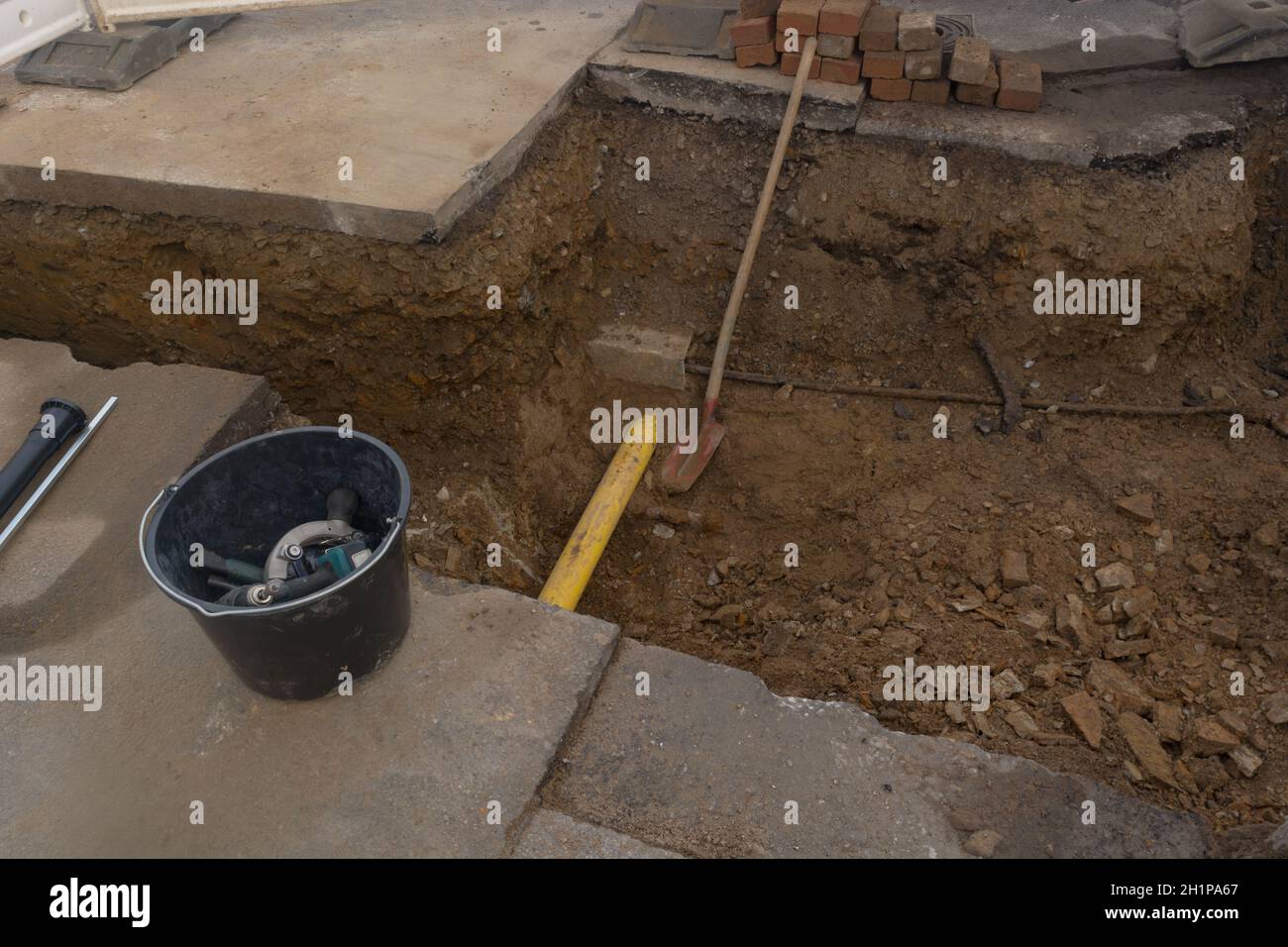 Arbeiten an der Installation von Engineering- und Heizsystemen. Zwei Kunststoffrohre, eine gelbe für Gasleitung und eine schwarze für Stromleitungen. Sie befinden sich in einer SA Stockfoto
