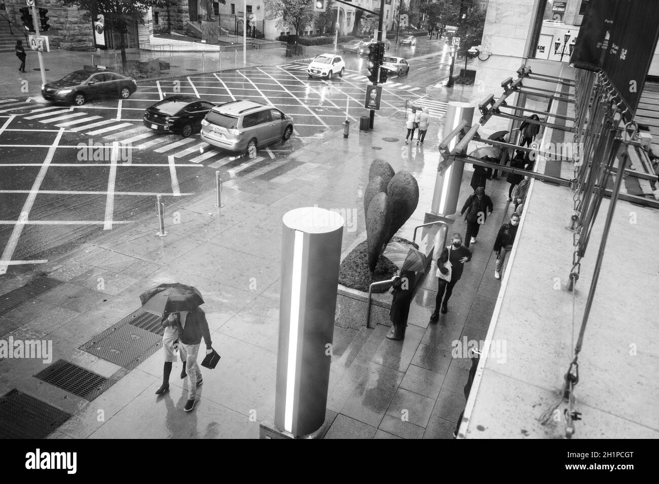 Fußgänger flanieren an einem regnerischen Tag auf der Sherbrooke Street in Montreal, Quebec, Kanada, in der Nähe des Montreal Museum of Fine Arts Stockfoto