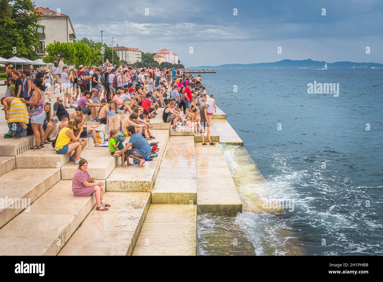 Zadar, Kroatien, Juli 2019 die Menge der Touristen hören Meeresorgel, Morske orgulje, Sound Art Objekt, das Musik über Meereswellen und Röhren spielt Stockfoto